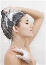 Woman washing hair in shower.