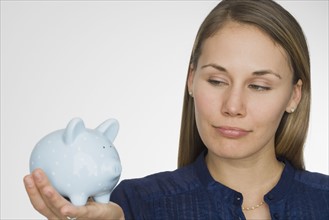 Woman holding piggy bank.