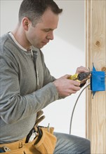Male electrician cutting wire.