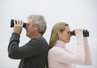 Couple looking through binoculars.
