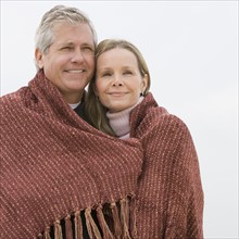 Couple wrapped in blanket.