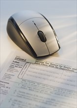Computer mouse next to tax form.