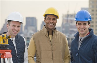 Multi-ethnic male construction workers wearing hard hats.