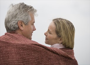 Couple wrapped in blanket.