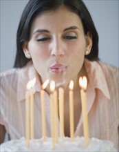Woman blowing out birthday candles.