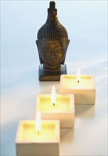 Buddha statue next to lit candles.