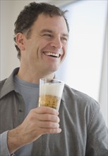 Man holding glass of beer.