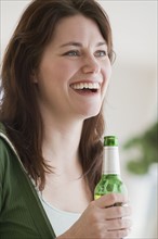 Woman holding bottle of beer.