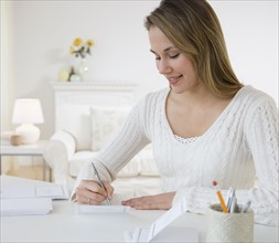 Woman writing at desk.