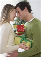 Couple with gifts hugging.