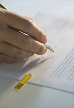 Close up of man signing paperwork.