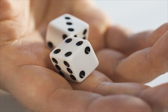 Close up of dice in man’s hand.