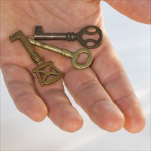 Close up of old fashioned keys in man’s hand.
