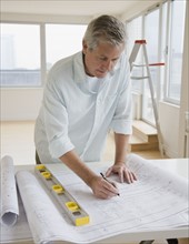 Man writing on blueprints.