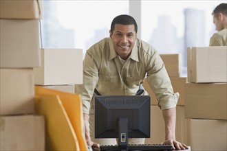 African delivery man next to computer.
