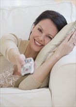 Woman pointing remote control.