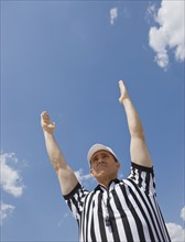 Male football referee making touchdown call.