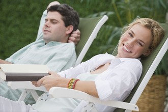 Couple relaxing in lounge chairs.