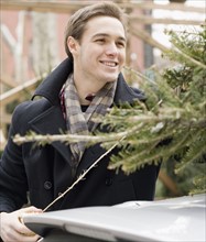 Man next to Christmas tree on car. Date : 2008