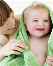 Mother drying baby with towel. Date : 2008
