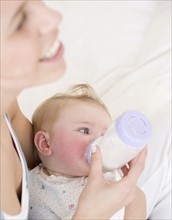 Mother feeding baby with bottle. Date : 2008