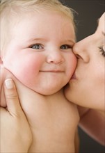 Mother kissing baby’s cheek. Date : 2008