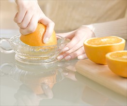 Woman squeezing oranges. Date : 2008