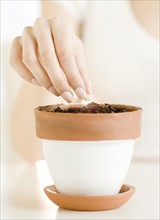 Woman planting seed in pot. Date : 2008