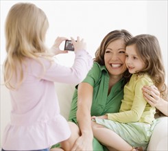 Girl taking photograph of mother and sister. Date : 2008