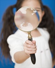 Hispanic girl holding magnifying glass. Date : 2008