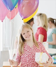 Girl holding balloons and gift. Date : 2008