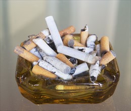 ashtray filled with many cigarette butts. Date : 2008