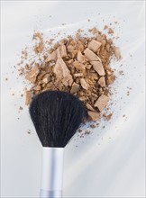 Close up of crushed cosmetic and brush.