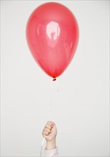 Child holding red balloon. Date : 2008