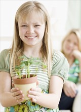 Girl holding potted plant. Date : 2008