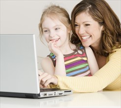 Mother and daughter looking at laptop. Date : 2008