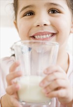 Hispanic girl holding glass of milk. Date : 2008