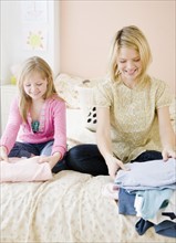 Mother and daughter folding clothing. Date : 2008