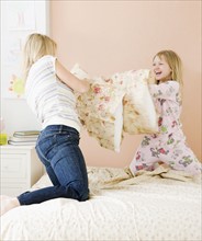 Mother and daughter having pillow fight. Date : 2008