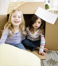 Sisters playing in cardboard box. Date : 2008