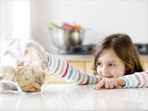 Girl reaching into cookie jar. Date : 2008
