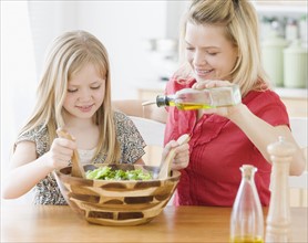 Mother and daughter making salad. Date : 2008