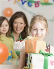 Girl holding stack of birthday gifts. Date : 2008