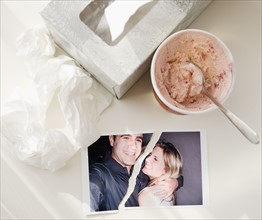 Ripped photograph next to ice cream and tissues. Date : 2008