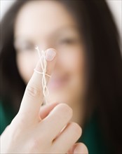 Woman with string tied around finger. Date : 2008