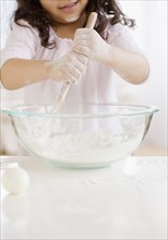 Hispanic girl mixing dough. Date : 2008