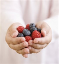 Child holding handful of berries. Date : 2008