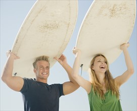 Couple holding surfboards on head. Date : 2008