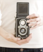 Woman holding old fashioned camera. Date : 2008