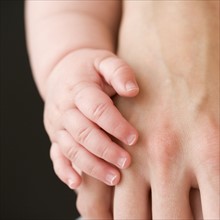 Close up of baby touching mother’s hand. Date : 2008